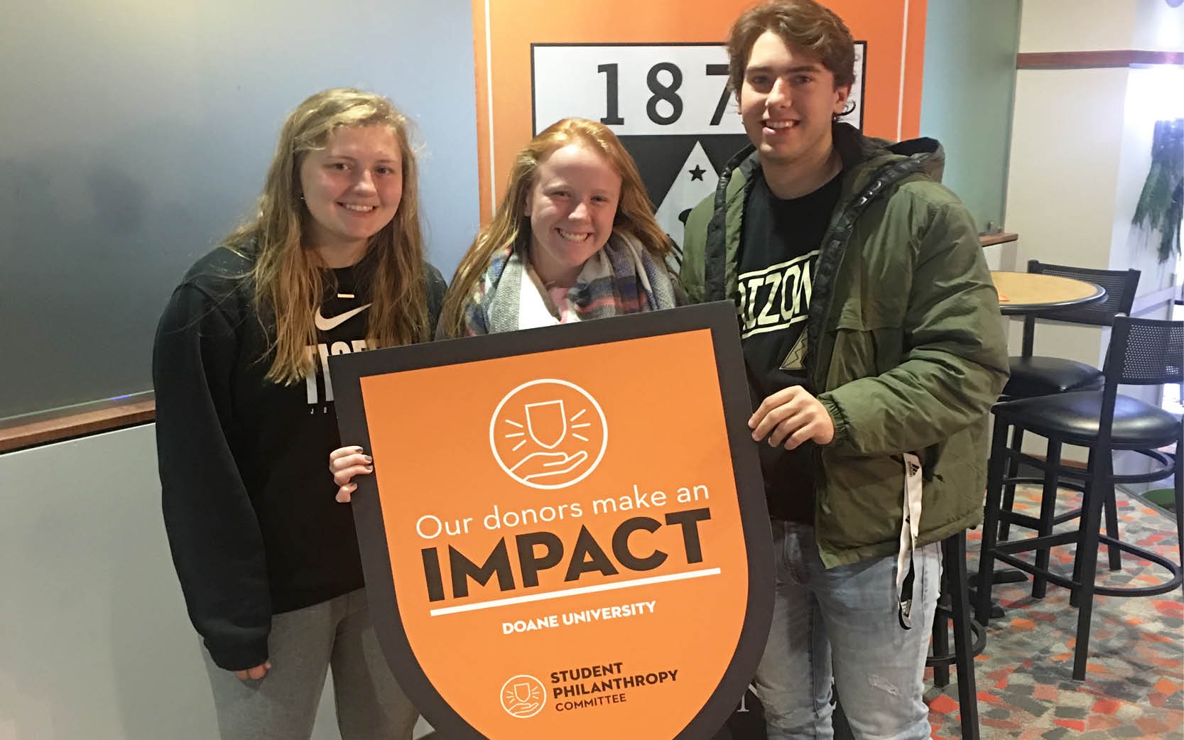 Students holding up an IMPACT banner in a classroom