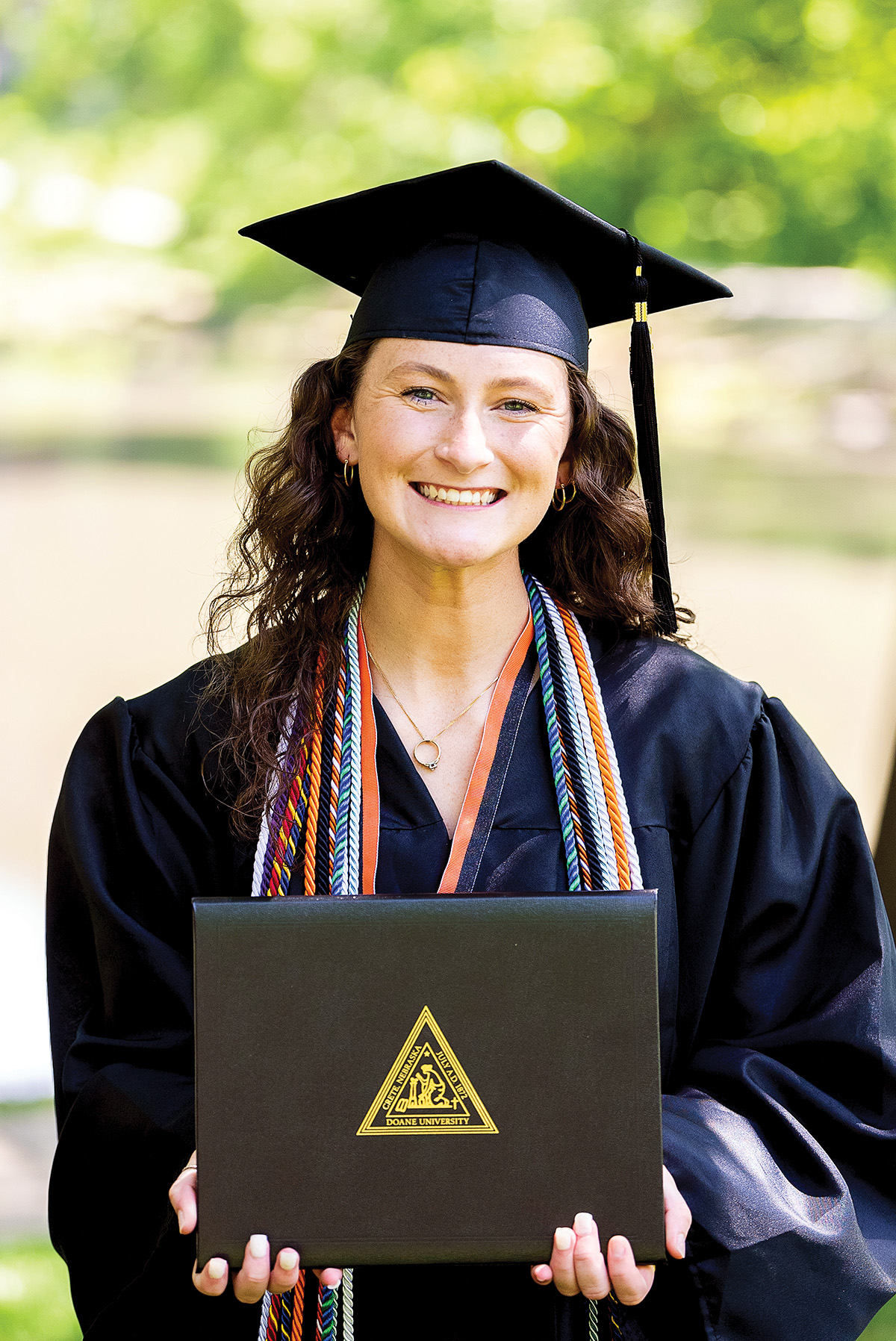 Payton Cooley ’24 stands holding her Doane diploma with pride.